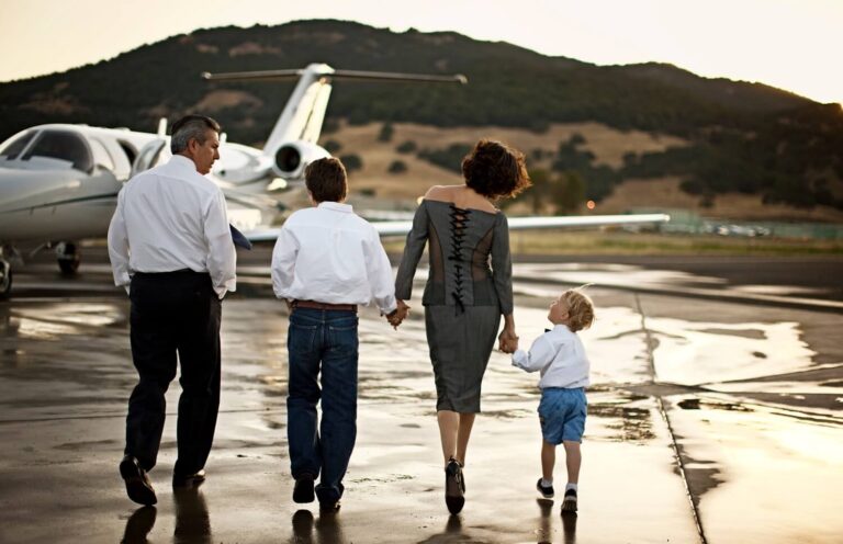 family walking towards a private jet holding hands