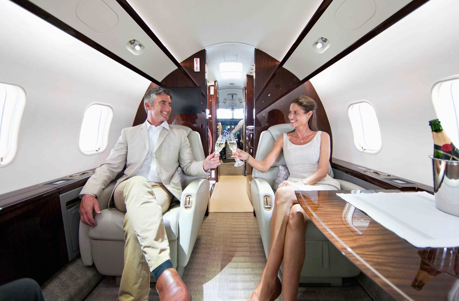 close up of a smiling couple making a toast in a private plane