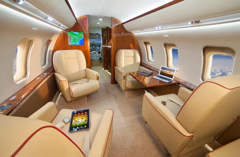 inside view of luxury jet with an ipad and macbook on the tables