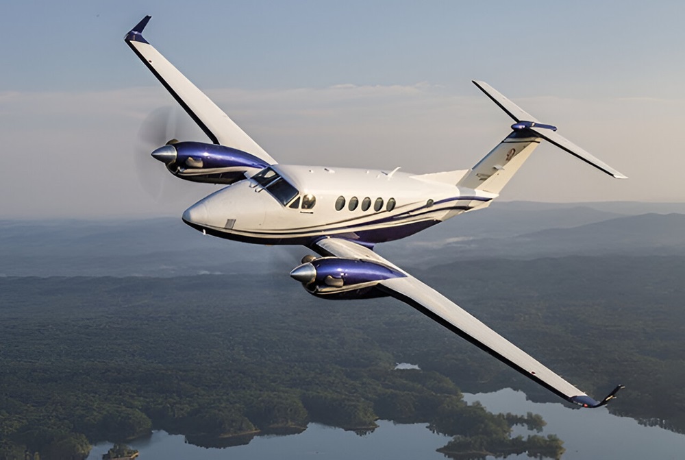 King Air 200 flying over trees