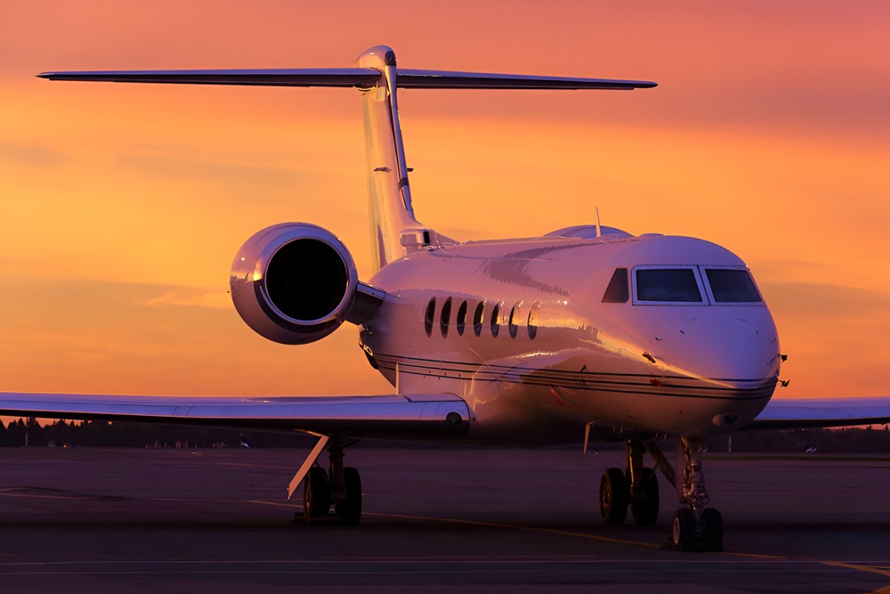 business jet standing on a parking position during sunrise