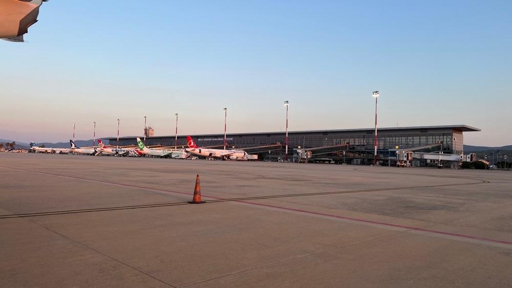 Milas Bodrum Airport (BJV) transportation vehicles and building at sunset time