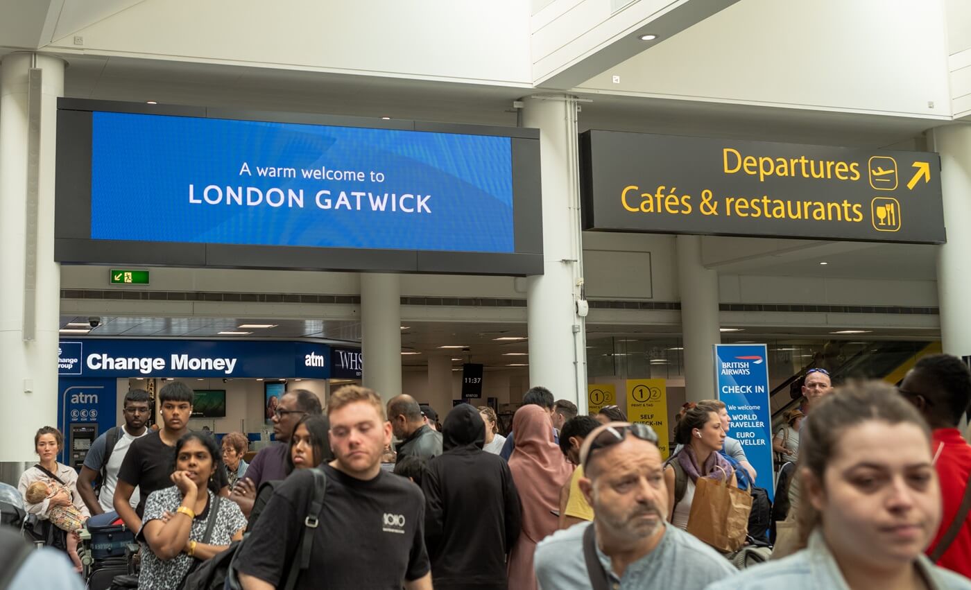 People queue to check in for flights at London Gatwick Airport