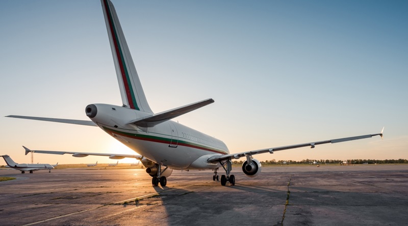 view of passenger airplane on airport apron and few other planes in the background