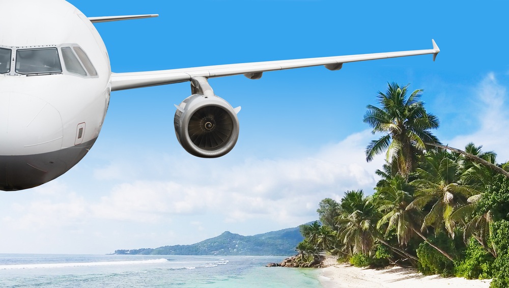 airplane is flying over island and sea in summer at seychelles