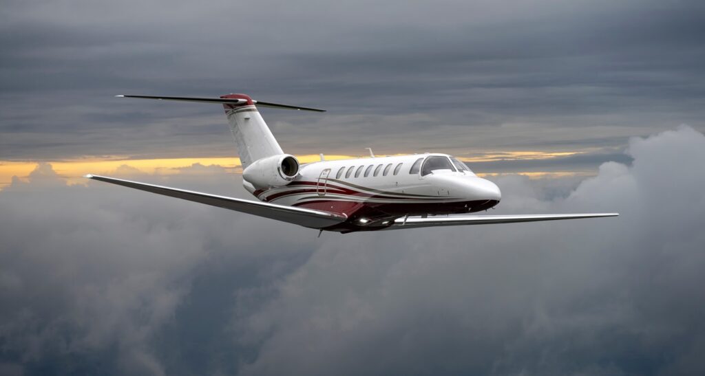 private jet flies high above the clouds