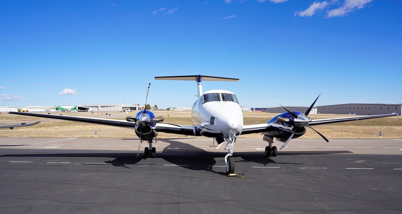 Sleek Twin Engine Turbo Prop Airplane Parked at an Airport on a Sunny Day