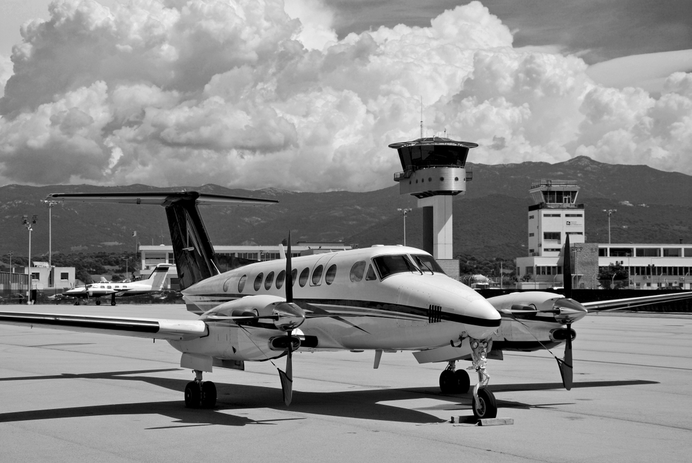 Beechcraft King Air 350 parked on the tarmac on a black and white shot with stormy clouds and sky