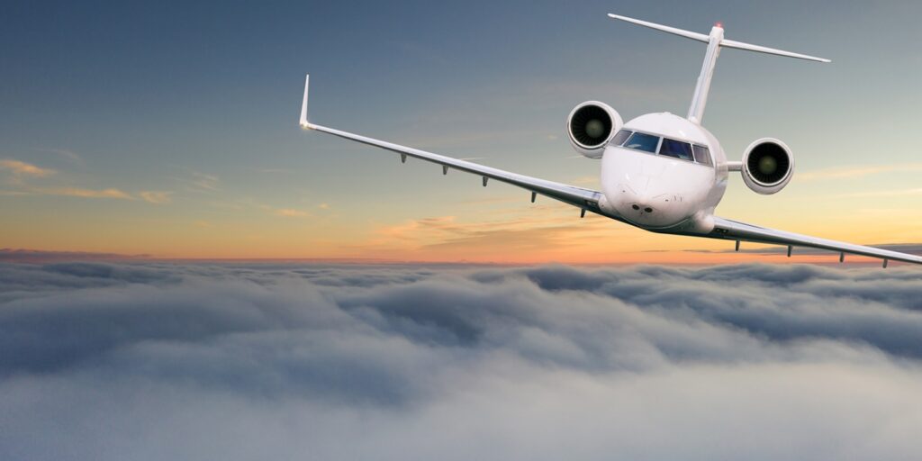 small private jetplane flying above beautiful clouds