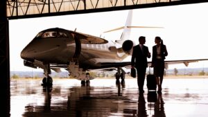 Silhouette of Businessman and Businesswoman walking away from the private jet in hangar