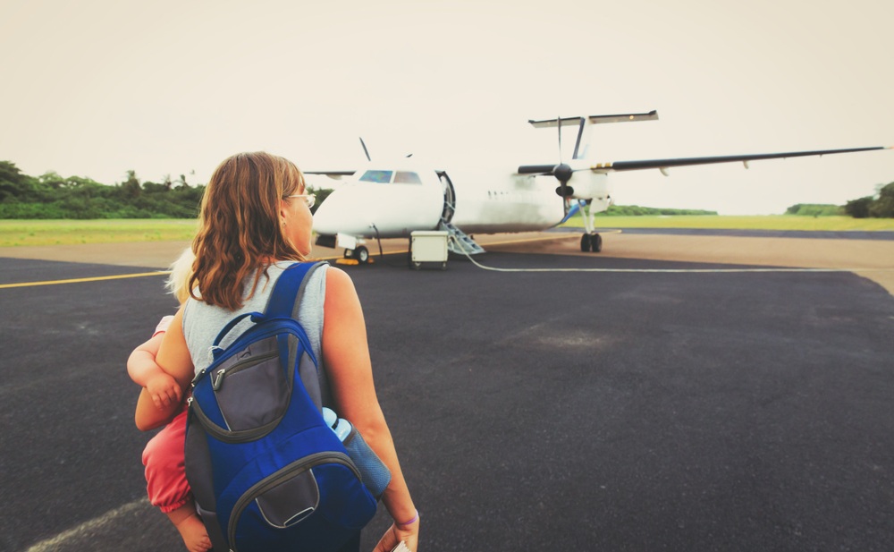 mother with little daughter coming to plane for boarding