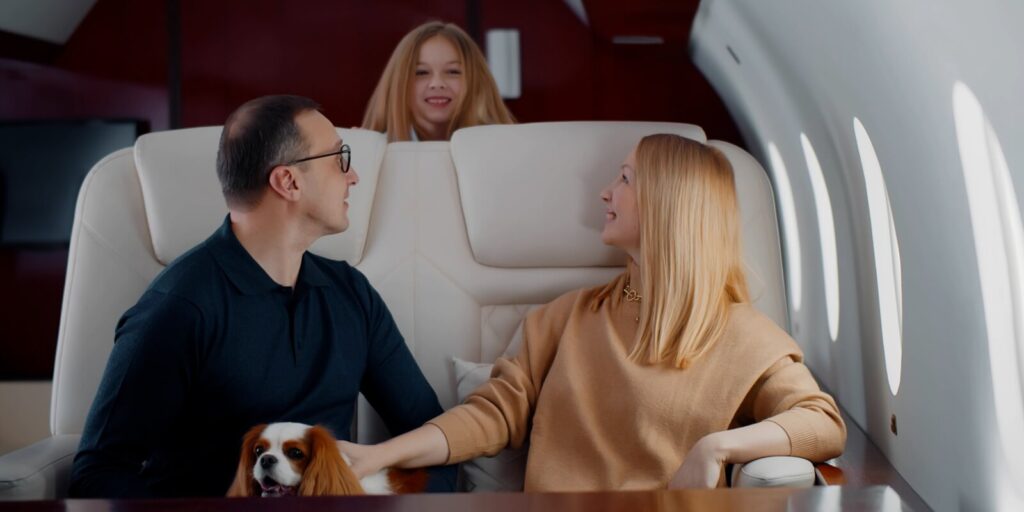 wealthy family with preteen daughter and cocker spaniel dog flying together on private jet