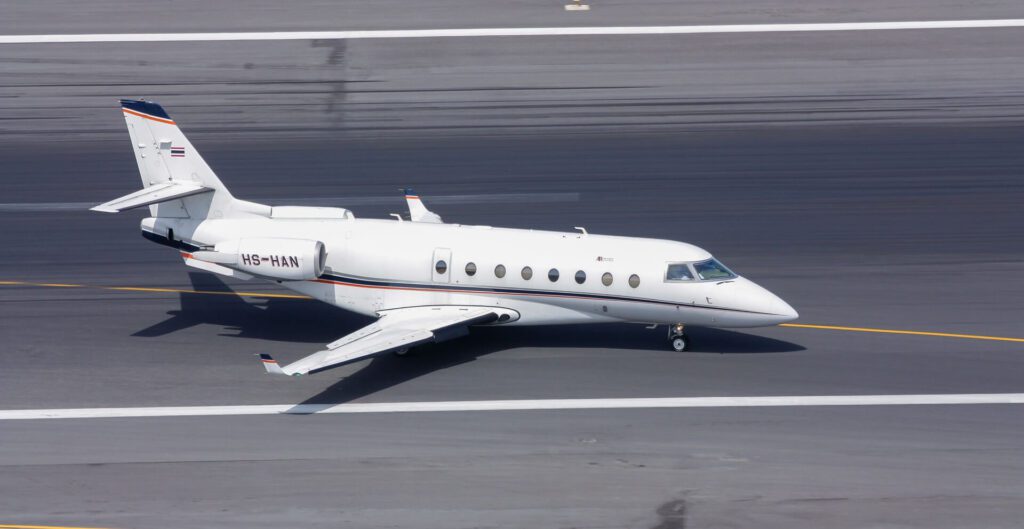 Private Jet Gulfstream 200 Code HS-HAN taxi on runway approach to Domestic Bulding of Phuket INternational Airport